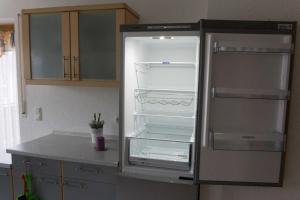 a refrigerator with its door open in a kitchen at Ferienwohnung Weiher - Nähe Nürnberg / Messe in Schwanstetten
