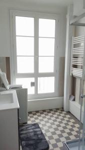 uma cozinha com uma janela e um piso em xadrez em Spacieux 2 pièces dans l'hyper-centre em Royan