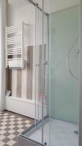 uma cabina de duche em vidro numa casa de banho com piso em xadrez em Spacieux 2 pièces dans l'hyper-centre em Royan