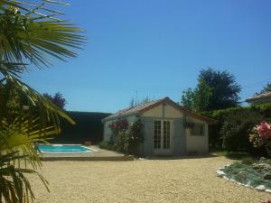 a small house next to a swimming pool at Chambres d'hôtes du Parc d'Espagne in Pessac