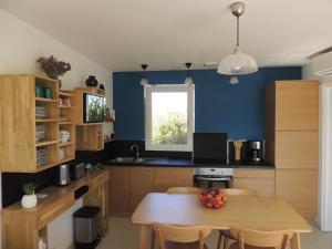 eine Küche mit einem Holztisch und blauen Wänden in der Unterkunft Mas Les Romarins in Montesquieu