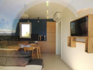 ein Wohnzimmer mit einem Tisch und einem TV an der Wand in der Unterkunft Mas Les Romarins in Montesquieu