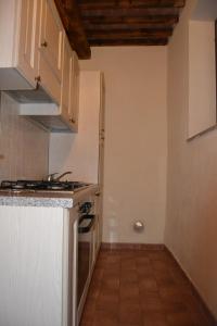 a kitchen with white cabinets and a stove top oven at Antico Borgo Casalappi in Campiglia Marittima