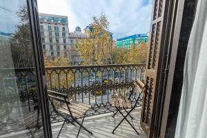 a balcony with chairs and a view of a city at Hostalin Barcelona Passeig de Gracia in Barcelona