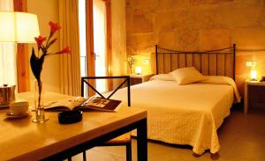 a hotel room with a bed and a desk at L'Hostal Pollença - Turisme Interior in Pollença