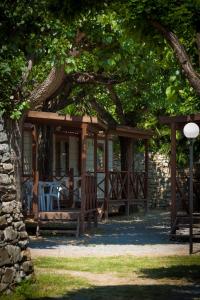 a cabin with a table and chairs under a tree at Campeggio Pian Dei Boschi in Pietra Ligure