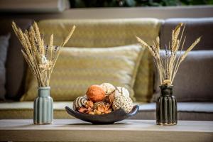 アムーダラ・イラクリオンにあるLino Mare Boutique Hotelの花瓶二つをテーブルに並べたナッツ鉢