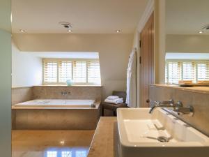 a bathroom with a bath tub and a sink at Gidleigh Park- A Relais & Chateaux Hotel in Chagford