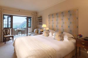 - une chambre avec un grand lit et une grande fenêtre dans l'établissement Gidleigh Park- A Relais & Chateaux Hotel, à Chagford