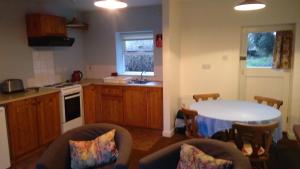 a kitchen with a table and chairs in a room at Ardtarmon Garden Cottage in Sligo