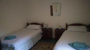 a room with two beds and two night stands at Ardtarmon Garden Cottage in Sligo