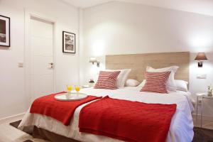 sypialnia z dużym łóżkiem i czerwonym kocem w obiekcie Feelathome Madrid Suites Apartments w Madrycie +37 zdjęć