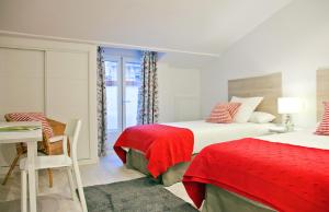 sypialnia z 2 łóżkami, stołem i biurkiem w obiekcie Feelathome Madrid Suites Apartments w Madrycie