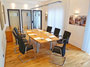 una sala de conferencias con mesa de madera y sillas negras en Hotel Zielonka, en Hochheim am Main