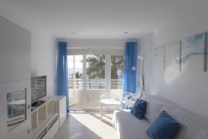 a living room with a white couch and a television at Apartamento Mediterráneo in Rincón de la Victoria