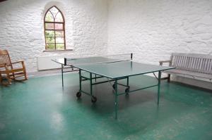 a ping pong table in a room with a bench at Ardtarmon Garden Cottage in Sligo