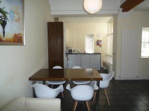 une salle à manger avec une table en bois et des chaises blanches dans l'établissement Castlemartyr Holiday Mews 2 bed, à Castlemartyr