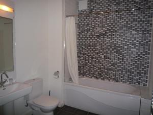 a bathroom with a toilet and a tub and a sink at Castlemartyr Holiday Mews 2 bed in Castlemartyr