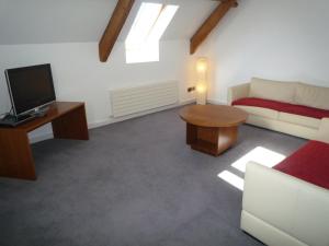 a living room with a couch and a tv at Castlemartyr Holiday Mews 3 bed in Castlemartyr