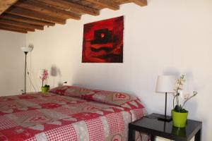 フィレンツェにあるArt Apartment Santo Spirito Matteoのベッドルーム1室(ベッド1台付)が備わります。壁には絵画が飾られています。