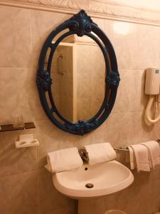 a bathroom with a sink and a mirror at Hôtel Sampiero in Bastia