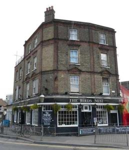 a large brick building on the corner of a street at The Birds Nest Hostel in London