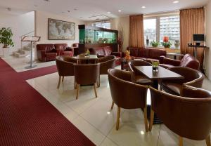 a waiting room with couches and tables and chairs at PREMIUM Business Hotel Bratislava in Bratislava