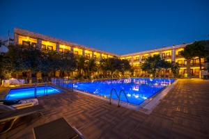 una grande piscina di fronte a un edificio di notte di Iris Hotel & Spa a Çanakkale