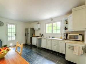 una cocina con armarios blancos y un bol de fruta en una mesa en Beautiful riverside villa in Entrecasteaux, en Entrecasteaux