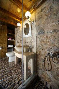 uma casa de banho em pedra com um lavatório e um WC em Citta dei Nicliani em Koíta