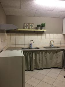 una cocina con una mesa con dos lavabos. en Allesø Gl. sognefoged gård, en Odense
