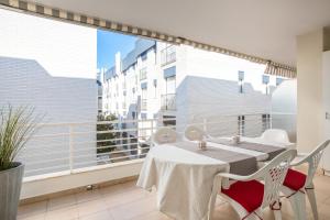 balcón con mesa y sillas y ventana grande en Lets Holidays White apartment with terrace, ac & parking, near beach, en Tossa de Mar