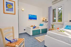 a room with two beds and a chair in it at Villa Ginestra - Scopello-Villas in Scopello