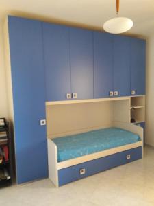 um quarto com armários azuis e uma cama nele em camera zona policlinico/università em Monserrato