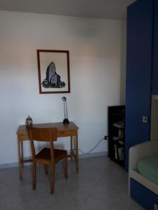 um quarto com uma secretária com uma cadeira e um candeeiro em camera zona policlinico/università em Monserrato