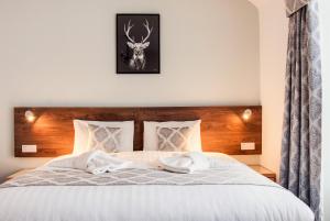 a bedroom with a white bed with a deer on the wall at St Ives Boutique Hotel in Dunoon