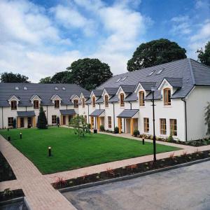 a large white house with a green yard at Heyward Mews Holiday Homes in Swords