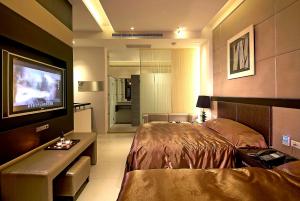 een slaapkamer met een bed en een flatscreen-tv bij Qi Hai Motel in Zhunan
