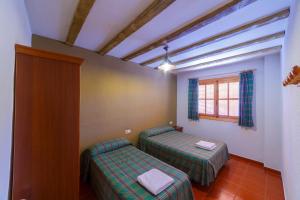 アルカラ・デル・フカルにあるApartamentos Ribera del Júcarのベッド2台と窓が備わる客室です。