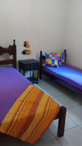 um quarto com duas camas e uma mesa em Casa na Praia do Forte em Cabo Frio