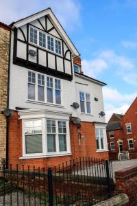 a white and red house with a black fence at Parks Nest 3 in Hull