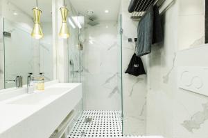 a white bathroom with a shower and a sink at Hotel Sveitsi in Hyvinkää