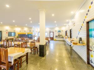 a restaurant with tables and chairs in a room at Hotel Venice Ubatuba in Ubatuba