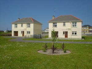 a house with a plant in the middle of a yard at Seacrest Holiday Homes in Bundoran