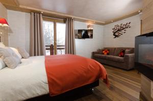 a bedroom with a bed and a couch and a television at Chalet Emilie in Courchevel