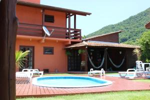 a house with a swimming pool in front of a house at Green Mountain Pousada in Florianópolis
