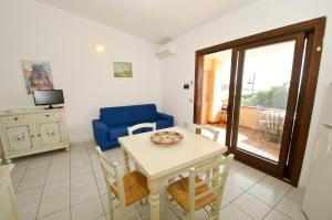 sala de estar con mesa y silla azul en A.I.R. Isola Rossa Borgo di Mare, en Isola Rossa