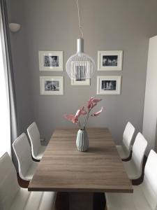 a dining room with a table with a vase of flowers at Apartment Feel Good in Zagreb