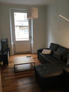 Sala de estar con sofá negro y mesa de centro en JLGR3, en Belfort
