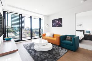 a living room with a couch and a table at Ilixir Apartments by Ready Set Host in Cheltenham